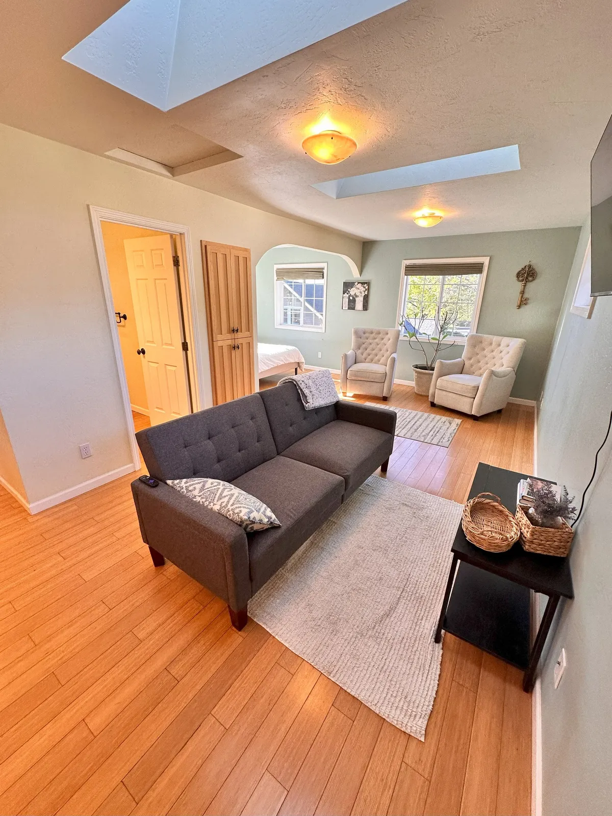 An inviting living room with a comfortable sofa, armchairs, and a well-decorated coffee table set on a cozy rug by a large window. The ambiance is warm and perfect for board games, conversations, or relaxing after a day of exploring.